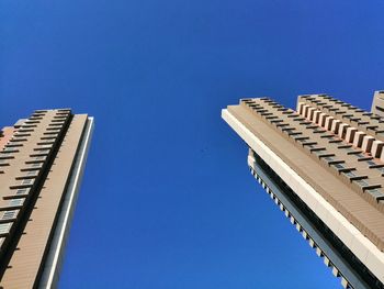 Low angle view of modern building against clear blue sky