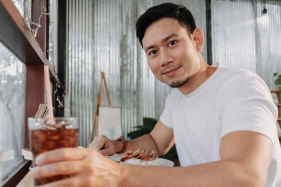 Portrait of young man sitting on table