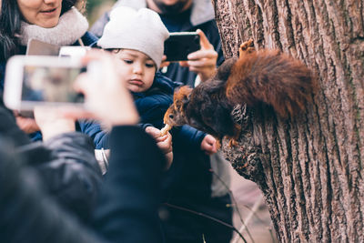 Young man photographing through smart phone outdoors