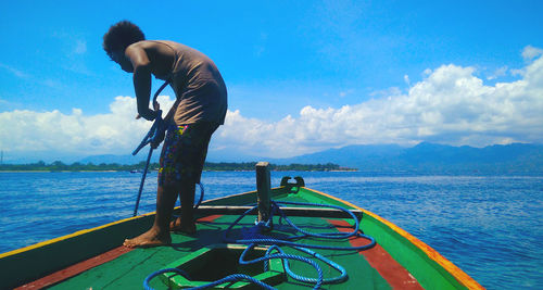 Man standing in sea against sky