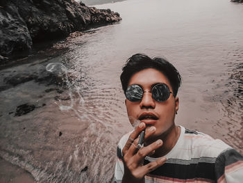 Portrait of young woman in sunglasses at beach