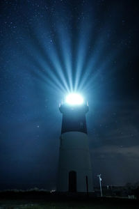 Low angle view of lighthouse against sky at night