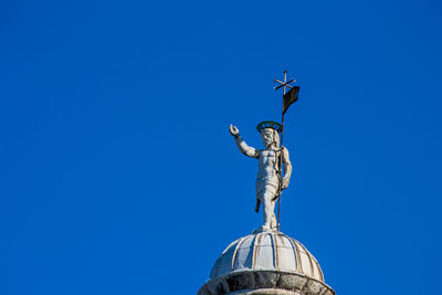 Low angle view of statue against blue sky