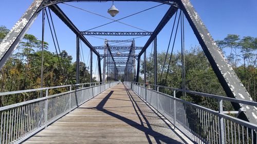 Footbridge over river against clear sky