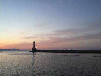 Silhouette boat sailing in sea against sky during sunset