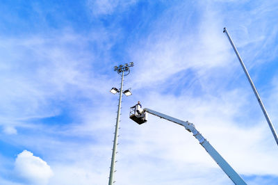 Low angle view of birds on cable against sky