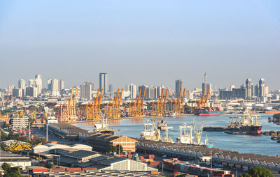 Cityscape by sea against sky