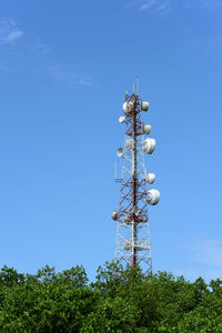 Low angle view of communications tower against blue sky