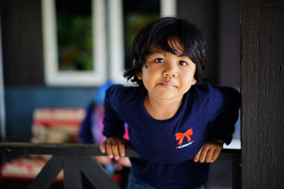 Portrait of girl leaning on railing at home