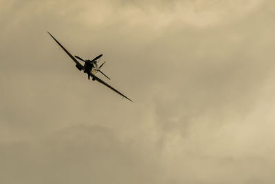 Low angle view of supermarine spitfire against cloudy sky at dusk