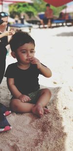 Cute boy sitting at beach