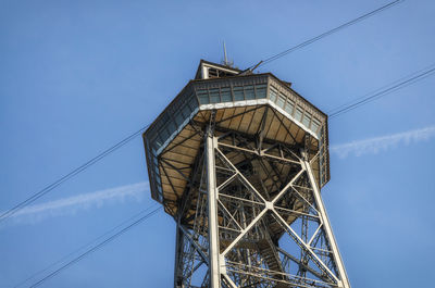 Low angle view of communications tower against blue sky