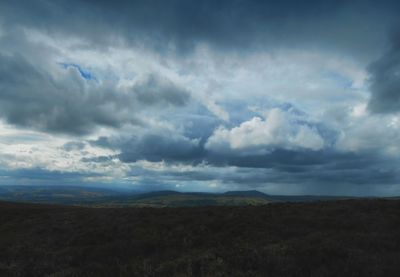 Countryside landscape against cloudy sky