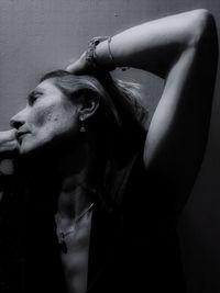 Close-up portrait of young woman against wall