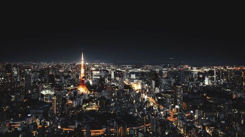 Illuminated cityscape against sky at night