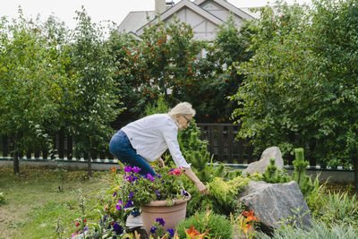 Senior woman by flowers and plants in garden