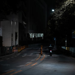 Rear view of man on illuminated street at night