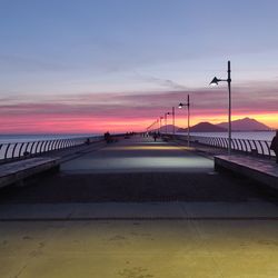 Bridge over road against sky during sunset