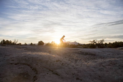 A woman on a sunrise mountain bike ride, gooseberry mesa, utah