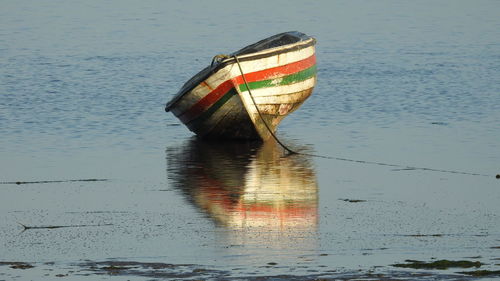 Boat moored in lake against sky