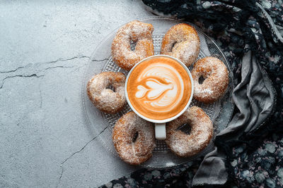 Coffee with latte art and small doughnut of wine with sugar and cinnamon and ingredients. donuts dessert