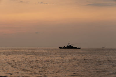 Silhouette ship in sea against sky during sunset