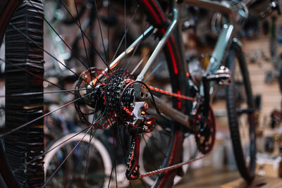 Closeup soft focus of rare derailleur on bicycle with wheel and chain placed in workshop during maintenance works