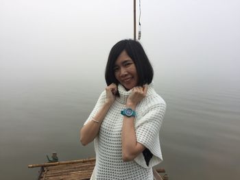 Portrait of smiling young woman standing in water