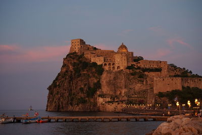 Buildings at waterfront during sunset