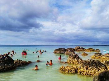 People on beach against sky