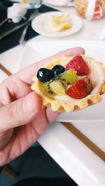 Cropped image of hand holding dessert at table