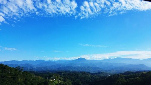 Scenic view of mountains against blue sky
