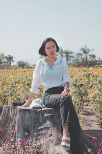 Full length of young woman sitting on field