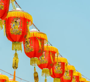 Low angle view of lanterns hanging against clear sky