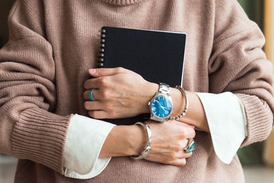 Cropped picture fashion woman in brown oversize sweater with stylish accessories