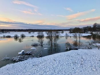 Scenic view of frozen lake against sky during sunset