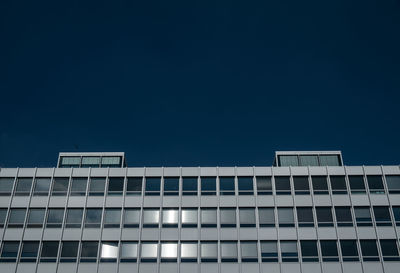 Low angle view of modern office building against clear blue sky