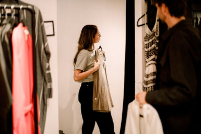 Side view of woman with clothing in retail store