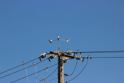 Low angle view of crane against clear blue sky