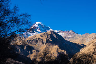 Scenic view of snowcapped mountains against clear blue sky