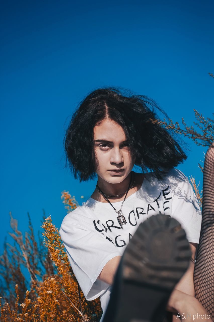 PORTRAIT OF BEAUTIFUL YOUNG WOMAN AGAINST SKY