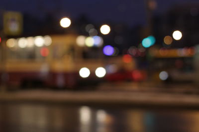 Defocused image of cars on road in city at night