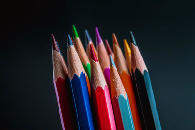 Close-up of colored pencils against black background