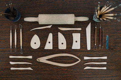 Directly above shot of rolling pin arranged with tools on wooden table