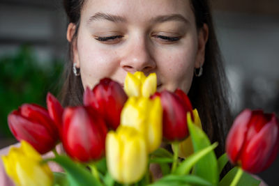 Close-up of young woman with red flower