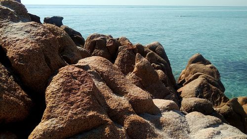 Rock formation on beach against sky