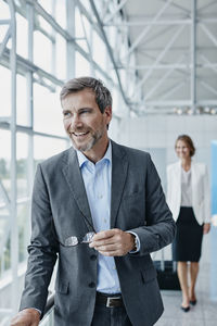 Smiling businessman and businesswoman at the airport