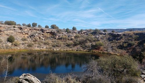 Scenic view of trees and rocks against sky