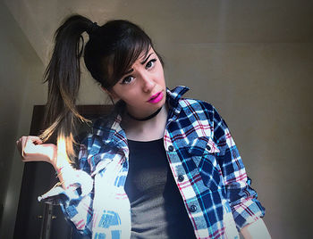 Portrait of woman standing against wall