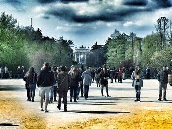 People looking at view against cloudy sky